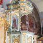 Zdjęcie nr 1: Ambona przyścienna, wisząca, z dostępem od strony prezbiterium w postaci jednobiegowych schodów z pełną balustradą dekorowaną dwoma płycinami w kształcie rombów oraz poręczą w formie gzymsu, zakończoną filarem z rokokowym wazonem. Kosz na planie kwadratu o ściętych narożach i wklęsłych bokach, na profilowanym cokole; u spodu podwieszony ostrosłup o wklęsłych bokach, z wolutami w narożach, zakończony szyszką w formie rocaille'u. Ścianki kosza flankowane pilastrami w formie spływów wolutowych z płyciną pośrodku w kształcie stojącego prostokąta o wklęsłych górnych i spodnich bokach; w polu ścianek kosza płyciny analogiczne jak na spływach wolutowych z dekoracją rocaille'ową w polu. Parapet w postaci profilowanego gzymsu. Zaplecek w kształcie stojącego prostokąta o wklęsłych bokach, ujętych spływami wolutowymi. W polu obraz Chrystusa Dobrego Pasterza umieszczony w płycinie w formie stojącego prostokąta o wklęsłych bokach, zamkniętego łukiem nadwieszonym z uskokami; u góry rocaille i rozety. Zaplecek flankowany uszami w postaci strzępionych liści. Baldachim na planie analogicznym jak kosz w postaci pełnego belkowania dekorowanego ornamentem rocaille'owym. Belkowanie stanowi podstawę dla czterech wolutowych kabłąków, dźwigających cokół z rokokowym wazonem. U spodu baldachimu rzeźbiona gołębica Ducha Świętego w promienistej glorii. Struktura polichromowana w kolorze seledynowym z ciemniejszymi profilami, ornamentyka złocona, gołębica srebrzona.
