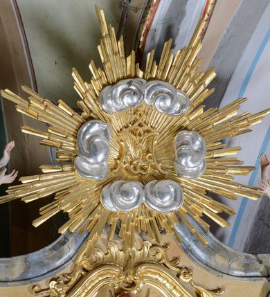 Zdjęcie nr 11: Nastawa ołtarzowa architektoniczna, jednoosiowa, jednokondygnacyjna ze zwieńczeniem. Ołtarz drewniany, prostopadłościenny, mensa drewniana z kamiennym portatylem. Antepedium w kształcie leżącego prostokąta, ujętego profilowaną ramą z aplikowanym monogramem Maryii w polu. Na ołtarzu ustawiony obraz Matki Boskiej Nieustającej Pomocy. Retabulum ustawione na dwustrefowym cokole, ujęte parą kolumn o kapitelach kompozytowych, przewiązanych poniżej połowy rocaille&#039;ową opaską, stojących na tle zwielokrotnionych pilastrów. Podpory dźwigają pełne belkowanie, wyłamane na ich osi, ustawione ukośnie, nad polem środkowym przyjmujące kształt łuku odcinkowego. W polu środkowym głęboka nisza w formie stojącego prostokąta zamkniętego łukiem wklęsło-wypukłym z uskokami, ujęta profilowaną ramą, z figurą Matki Boskiej z Lourdes. Niszę flankują dwie figury: św. Jana i św. Mateusza ustawione na konsolach. Na belkowaniu, na linii podpór cokoły z figurami św. Emeryka i św. Władysława. Zwieńczenie przyjmuje kształt stojącego prostokąta flankowanego spływami wolutowymi, zamkniętego gzymsem przechodzącym w dwie woluty. Całość zakończona promienistą glorią z monogramem Marii otoczonym obłokami, flankowana figurkami aniołków. W polu zwieńczenia rama w formie stojącego prostokąta o wklęsłych bokach i dolnych narożach, zamknięta wolutami, z figurą św. Stefana w polu, ustawioną na wsporniku. Nastawa ujęta po bokach ażurowymi uszami utworzonymi z rocaille&#039;u i prostej karbowanej wstęgi. Całość obficie dekorowana ornamentem rocaille&#039;owym oraz zwisami kwiatowymi. Struktura marmoryzowana w kolorze żółtym, profile marmoryzowane na seledynowo, ornamentyka i profilowania złocone.

