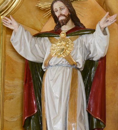 Zdjęcie nr 4: Nastawa ołtarzowa architektoniczna, jednoosiowa, jednokondygnacyjna ze zwieńczeniem. Ołtarz drewniany, prostopadłościenny, mensa drewniana z kamiennym portatylem. Antepedium w kształcie leżącego prostokąta, ujętego profilowaną ramą. Na ołtarzu tabernakulum w formie prostopadłościennej skrzynki, ujętej w narożach pilastrami o ornamentalnych trzonach, dźwigających pełne belkowanie opasujące tabernakulum z trzech stron, wyłamane na ich osi. Drzwiczki w formie stojącego prostokąta zamkniętego łukiem nadwieszonym. Retabulum ustawione na dwustrefowym cokole, ujęte parą kolumn o kapitelach kompozytowych, stojących na tle zwielokrotnionych pilastrów. Podpory dźwigają pełne belkowanie, wyłamane na ich osi, ustawione ukośnie, nad polem środkowym przyjmujące kształt łuku odcinkowego. W polu środkowym głęboka nisza w formie stojącego prostokąta zamkniętego łukiem wklęsło-wypukłym z uskokami, ujęta profilowaną ramą, z figurą Najświętszego Serca Jezusa. Niszę flankują dwie figury: św. Marka i św. Łukasza ustawione na konsolach. Na belkowaniu, na linii podpór cokoły z figurami św. Alojzego Gonzagi i św. Rocha. Zwieńczenie przyjmuje kształt stojącego prostokąta flankowanego spływami wolutowymi, zamkniętego gzymsem przechodzącym w dwie woluty. Całość zakończona owalnym medalionem z płaskorzeźbionym przedstawieniem Trójcy Świętej w promienistej glorii, flankowana figurkami św. Katarzyny Aleksandryjskiej i nierozpoznanej świętej. W polu zwieńczenia rama w formie stojącego prostokąta o wklęsłych bokach i dolnych narożach, zamknięta wolutami z akroterionem, z figurą św. Sebastiana w polu, ustawioną na wsporniku. Nastawa ujęta po bokach ażurowymi uszami utworzonymi z akantu i prostej karbowanej wstęgi. Całość obficie dekorowana ornamentem rocaille&#039;owym oraz zwisami kwiatowymi. Struktura marmoryzowana w kolorze żółtym, profile marmoryzowane na seledynowo, ornamentyka i profilowania złocone.