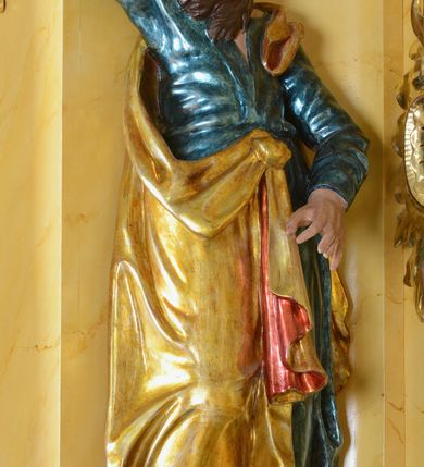 Zdjęcie nr 6: Nastawa ołtarzowa architektoniczna, jednoosiowa, jednokondygnacyjna ze zwieńczeniem. Ołtarz drewniany, prostopadłościenny, mensa drewniana z kamiennym portatylem. Antepedium w kształcie leżącego prostokąta, ujętego profilowaną ramą. Na ołtarzu tabernakulum w formie prostopadłościennej skrzynki, ujętej w narożach pilastrami o ornamentalnych trzonach, dźwigających pełne belkowanie opasujące tabernakulum z trzech stron, wyłamane na ich osi. Drzwiczki w formie stojącego prostokąta zamkniętego łukiem nadwieszonym. Retabulum ustawione na dwustrefowym cokole, ujęte parą kolumn o kapitelach kompozytowych, stojących na tle zwielokrotnionych pilastrów. Podpory dźwigają pełne belkowanie, wyłamane na ich osi, ustawione ukośnie, nad polem środkowym przyjmujące kształt łuku odcinkowego. W polu środkowym głęboka nisza w formie stojącego prostokąta zamkniętego łukiem wklęsło-wypukłym z uskokami, ujęta profilowaną ramą, z figurą Najświętszego Serca Jezusa. Niszę flankują dwie figury: św. Marka i św. Łukasza ustawione na konsolach. Na belkowaniu, na linii podpór cokoły z figurami św. Alojzego Gonzagi i św. Rocha. Zwieńczenie przyjmuje kształt stojącego prostokąta flankowanego spływami wolutowymi, zamkniętego gzymsem przechodzącym w dwie woluty. Całość zakończona owalnym medalionem z płaskorzeźbionym przedstawieniem Trójcy Świętej w promienistej glorii, flankowana figurkami św. Katarzyny Aleksandryjskiej i nierozpoznanej świętej. W polu zwieńczenia rama w formie stojącego prostokąta o wklęsłych bokach i dolnych narożach, zamknięta wolutami z akroterionem, z figurą św. Sebastiana w polu, ustawioną na wsporniku. Nastawa ujęta po bokach ażurowymi uszami utworzonymi z akantu i prostej karbowanej wstęgi. Całość obficie dekorowana ornamentem rocaille'owym oraz zwisami kwiatowymi. Struktura marmoryzowana w kolorze żółtym, profile marmoryzowane na seledynowo, ornamentyka i profilowania złocone.