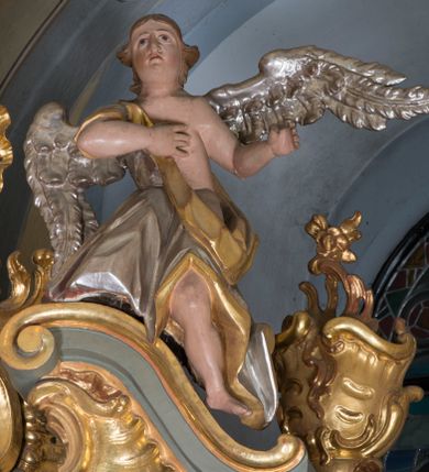 Zdjęcie nr 13: Nastawa ołtarzowa architektoniczna, jednoosiowa, jednokondygnacyjna ze zwieńczeniem i bramkami. Ołtarz drewniany, sarkofagowy, wklęsło-wypukły, zwężający się ku dołowi; dekorowany w narożach ornamentem rocaille&#039;owym, od frontu z rocaille&#039;owym kartuszem. Mensa z portatylem. Tabernakulum w formie zbliżonej do prostopadłościennej skrzynki, ustawione na niskim cokole, o wypukłej ściance frontowej; ujęte drewnianą obudową o wklęsłych bokach, flankowane parą ustawionych pod kątem pilastrów na wysokich cokołach, których trzony przyjmują formę wolut, nad nimi uskrzydlone główki aniołków. Zwieńczenie tabernakulum w formie profilowanego gzymsu, wyłamanego nad osiami bocznymi. Całość ujęta po bokach rocaille&#039;owymi uszami. Część środkowa nowa, miedziana z wypukłymi drzwiczkami w formie stojącego prostokąta zamkniętego łukiem nadwieszonym. W polu aplikowane przedstawienie pelikana karmiącego młode w gnieździe, z krzyżem, gorejącym sercem i arma Christi (włócznia i gąbka z octem) powyżej. Nad drzwiczkami rocaille&#039;owa wstęga. Nastawa ustawiona na zdwojonym cokole, o delikatnie wklęsłym przebiegu, ujęta parą pilastrów od wewnątrz oraz dwiema parami kolumn na skrajach, z których zewnętrzne są cofnięte. Podpory dźwigają pełne belkowanie, wyłamane pośrodku; na linii kolumn cokoły i fragmenty belkowania ustawione pod kątem. Pomiędzy podporami figury: po lewej św. Piotra, a po prawej św. Pawła, przed kolumnami: po lewej św. Jana Ewangelisty, a po prawej św. Andrzeja. Tabernakulum flankuje para rzeźbionych aniołów. W polu środkowym nisza w formie stojącego prostokąta, zamkniętego łukiem nadwieszonym w podwójnej profilowanej, złoconej i od wewnątrz ażurowej ramie z obrazem św. Marcina. Zwieńczenie w formie zbliżonej do leżącego prostokąta ujętego podwójnymi spływami wolutowymi, zamknięte szczytem utworzonym z ornamentu rocaille&#039;owego, po bokach wazony płomieniste. W polu figura Chrystusa Zmartwychwstałego w otoczeniu płaskorzeźbionych obłoków i uskrzydlonych główek anielskich. Na belkowaniu, nad środkową parą kolumn przerwany wolutowy przyczółek z figurami aniołów. Bramki z drzwiczkami w formie stojącego prostokąta, flankowane węgarami, zamknięte wolutowym łukiem z zatkniętym na szczycie wazonem płomienistym, w polu dekorowane rocaille&#039;owymi płycinami. Cokoły i trzony pilastrów dekorowane rocaille&#039;m, w polu między pilastrami, a kolumnami trzy pary kwiatowych zwisów. Nisza pola środkowego zwieńczona rocaille&#039;owym kartuszem. Struktura polichromowana w kolorze seledynowym, profilowania i płyciny w kolorze ciemnoszarym, kapitele i rama obrazu w kolorze czerwonym, ornamentyka złocona, kolumny i obłoki srebrzone.