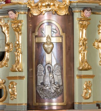 Zdjęcie nr 10: Nastawa ołtarzowa architektoniczna, jednoosiowa, jednokondygnacyjna ze zwieńczeniem i bramkami. Ołtarz drewniany, sarkofagowy, wklęsło-wypukły, zwężający się ku dołowi; dekorowany w narożach ornamentem rocaille'owym, od frontu z rocaille'owym kartuszem. Mensa z portatylem. Tabernakulum w formie zbliżonej do prostopadłościennej skrzynki, ustawione na niskim cokole, o wypukłej ściance frontowej; ujęte drewnianą obudową o wklęsłych bokach, flankowane parą ustawionych pod kątem pilastrów na wysokich cokołach, których trzony przyjmują formę wolut, nad nimi uskrzydlone główki aniołków. Zwieńczenie tabernakulum w formie profilowanego gzymsu, wyłamanego nad osiami bocznymi. Całość ujęta po bokach rocaille'owymi uszami. Część środkowa nowa, miedziana z wypukłymi drzwiczkami w formie stojącego prostokąta zamkniętego łukiem nadwieszonym. W polu aplikowane przedstawienie pelikana karmiącego młode w gnieździe, z krzyżem, gorejącym sercem i arma Christi (włócznia i gąbka z octem) powyżej. Nad drzwiczkami rocaille'owa wstęga. Nastawa ustawiona na zdwojonym cokole, o delikatnie wklęsłym przebiegu, ujęta parą pilastrów od wewnątrz oraz dwiema parami kolumn na skrajach, z których zewnętrzne są cofnięte. Podpory dźwigają pełne belkowanie, wyłamane pośrodku; na linii kolumn cokoły i fragmenty belkowania ustawione pod kątem. Pomiędzy podporami figury: po lewej św. Piotra, a po prawej św. Pawła, przed kolumnami: po lewej św. Jana Ewangelisty, a po prawej św. Andrzeja. Tabernakulum flankuje para rzeźbionych aniołów. W polu środkowym nisza w formie stojącego prostokąta, zamkniętego łukiem nadwieszonym w podwójnej profilowanej, złoconej i od wewnątrz ażurowej ramie z obrazem św. Marcina. Zwieńczenie w formie zbliżonej do leżącego prostokąta ujętego podwójnymi spływami wolutowymi, zamknięte szczytem utworzonym z ornamentu rocaille'owego, po bokach wazony płomieniste. W polu figura Chrystusa Zmartwychwstałego w otoczeniu płaskorzeźbionych obłoków i uskrzydlonych główek anielskich. Na belkowaniu, nad środkową parą kolumn przerwany wolutowy przyczółek z figurami aniołów. Bramki z drzwiczkami w formie stojącego prostokąta, flankowane węgarami, zamknięte wolutowym łukiem z zatkniętym na szczycie wazonem płomienistym, w polu dekorowane rocaille'owymi płycinami. Cokoły i trzony pilastrów dekorowane rocaille'm, w polu między pilastrami, a kolumnami trzy pary kwiatowych zwisów. Nisza pola środkowego zwieńczona rocaille'owym kartuszem. Struktura polichromowana w kolorze seledynowym, profilowania i płyciny w kolorze ciemnoszarym, kapitele i rama obrazu w kolorze czerwonym, ornamentyka złocona, kolumny i obłoki srebrzone.