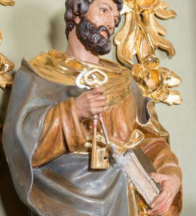 Zdjęcie nr 8: Nastawa ołtarzowa architektoniczna, jednoosiowa, jednokondygnacyjna ze zwieńczeniem i bramkami. Ołtarz drewniany, sarkofagowy, wklęsło-wypukły, zwężający się ku dołowi; dekorowany w narożach ornamentem rocaille&#039;owym, od frontu z rocaille&#039;owym kartuszem. Mensa z portatylem. Tabernakulum w formie zbliżonej do prostopadłościennej skrzynki, ustawione na niskim cokole, o wypukłej ściance frontowej; ujęte drewnianą obudową o wklęsłych bokach, flankowane parą ustawionych pod kątem pilastrów na wysokich cokołach, których trzony przyjmują formę wolut, nad nimi uskrzydlone główki aniołków. Zwieńczenie tabernakulum w formie profilowanego gzymsu, wyłamanego nad osiami bocznymi. Całość ujęta po bokach rocaille&#039;owymi uszami. Część środkowa nowa, miedziana z wypukłymi drzwiczkami w formie stojącego prostokąta zamkniętego łukiem nadwieszonym. W polu aplikowane przedstawienie pelikana karmiącego młode w gnieździe, z krzyżem, gorejącym sercem i arma Christi (włócznia i gąbka z octem) powyżej. Nad drzwiczkami rocaille&#039;owa wstęga. Nastawa ustawiona na zdwojonym cokole, o delikatnie wklęsłym przebiegu, ujęta parą pilastrów od wewnątrz oraz dwiema parami kolumn na skrajach, z których zewnętrzne są cofnięte. Podpory dźwigają pełne belkowanie, wyłamane pośrodku; na linii kolumn cokoły i fragmenty belkowania ustawione pod kątem. Pomiędzy podporami figury: po lewej św. Piotra, a po prawej św. Pawła, przed kolumnami: po lewej św. Jana Ewangelisty, a po prawej św. Andrzeja. Tabernakulum flankuje para rzeźbionych aniołów. W polu środkowym nisza w formie stojącego prostokąta, zamkniętego łukiem nadwieszonym w podwójnej profilowanej, złoconej i od wewnątrz ażurowej ramie z obrazem św. Marcina. Zwieńczenie w formie zbliżonej do leżącego prostokąta ujętego podwójnymi spływami wolutowymi, zamknięte szczytem utworzonym z ornamentu rocaille&#039;owego, po bokach wazony płomieniste. W polu figura Chrystusa Zmartwychwstałego w otoczeniu płaskorzeźbionych obłoków i uskrzydlonych główek anielskich. Na belkowaniu, nad środkową parą kolumn przerwany wolutowy przyczółek z figurami aniołów. Bramki z drzwiczkami w formie stojącego prostokąta, flankowane węgarami, zamknięte wolutowym łukiem z zatkniętym na szczycie wazonem płomienistym, w polu dekorowane rocaille&#039;owymi płycinami. Cokoły i trzony pilastrów dekorowane rocaille&#039;m, w polu między pilastrami, a kolumnami trzy pary kwiatowych zwisów. Nisza pola środkowego zwieńczona rocaille&#039;owym kartuszem. Struktura polichromowana w kolorze seledynowym, profilowania i płyciny w kolorze ciemnoszarym, kapitele i rama obrazu w kolorze czerwonym, ornamentyka złocona, kolumny i obłoki srebrzone.