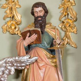 Zdjęcie nr 1: Rzeźba ścięta z tyłu, ustawiona na niskim cokole o ściętych z przodu narożach. Święty ustawiony frontalnie w postawie stojącej, w dużym kontrapoście z lewą nogą ugiętą w kolanie, z otwartą księgą w prawej dłoni oraz mieczem w lewej, ostrzem skierowanym w dół. Głowa skierowana w stronę księgi, twarz podłużna, nos długi i szeroki, oczy delikatnie przymknięte. Włosy ciemnobrązowe, średniej długości, zasłaniające uszy; broda długa i bujna. Święty jest ubrany w niebieską suknię, przewiązaną w talii oraz różowy płaszcz ze złotą podszewką i kapturem, na stopach sandały. Polichromia w odsłoniętych partiach ciała naturalistyczna, podbicie płaszcza złocone, ostrze miecza srebrzone.