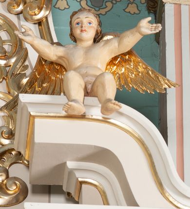 Zdjęcie nr 5: Ołtarz architektoniczny, przyścienny, jednoosiowy, jednokondygnacyjny ze zwieńczeniem. Nastawa umieszczona jest na skrzyniowej mensie z kamiennym blatem. Antepedium ozdabia okrągła płycina z otaczającym monogram IHS czteroliściem wpisanym w koło, flankowana przez dwie kwadratowe płyciny, których wewnętrzne krawędzie są wklęsłe. Boczne ścianki mensy ozdobione są prostokątną płyciną. Nastawa flankowana ustawionymi na wysuniętych partiach cokołu kolumnami dźwigającymi pełne belkowanie wyłamane na ich osiach i podtrzymujące fragmenty urwanego przyczółka. Cokół jest dekorowany prostokątnymi płycinami, na osiach zewnętrznych dodatkowo wypełnionymi ornamentem małżowinowym i rocaille’owym. W polu centralnym nisza zamknięta od góry łukiem spłaszczonym, w której znajduje się wizerunek św. Józefa z małym Jezusem. Poniżej niszy trzy płyciny z symetryczną dekoracją rocaille’ową, powyżej wstęga z napisem „BÓG UWIELBIONY I BŁ[OGOSŁAWIONY]” ujęta liśćmi. Kondygnacja jest z prawej strony ujęta uszakiem skomponowanym z ażurowej wici akantowej. Pole zwieńczenia wypełnia rama w kształcie stojącego owalu z wizerunkiem św. Stanisława Kostki, otoczona ornamentem inspirowanym małżowinowym. Powyżej muszla palmetowa, a na urwanych fragmentach przyczółka posadowiono anioły. 
Struktura polichromowana na kremowo ze złoconą i srebrzoną ornamentyką oraz detalami architektonicznymi.