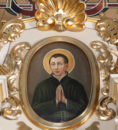 Zdjęcie nr 3: Ołtarz architektoniczny, przyścienny, jednoosiowy, jednokondygnacyjny ze zwieńczeniem. Nastawa umieszczona jest na skrzyniowej mensie z kamiennym blatem. Antepedium ozdabia okrągła płycina z otaczającym monogram IHS czteroliściem wpisanym w koło, flankowana przez dwie kwadratowe płyciny, których wewnętrzne krawędzie są wklęsłe. Boczne ścianki mensy ozdobione są prostokątną płyciną. Nastawa flankowana ustawionymi na wysuniętych partiach cokołu kolumnami dźwigającymi pełne belkowanie wyłamane na ich osiach i podtrzymujące fragmenty urwanego przyczółka. Cokół jest dekorowany prostokątnymi płycinami, na osiach zewnętrznych dodatkowo wypełnionymi ornamentem małżowinowym i rocaille’owym. W polu centralnym nisza zamknięta od góry łukiem spłaszczonym, w której znajduje się wizerunek św. Józefa z małym Jezusem. Poniżej niszy trzy płyciny z symetryczną dekoracją rocaille’ową, powyżej wstęga z napisem „BÓG UWIELBIONY I BŁ[OGOSŁAWIONY]” ujęta liśćmi. Kondygnacja jest z prawej strony ujęta uszakiem skomponowanym z ażurowej wici akantowej. Pole zwieńczenia wypełnia rama w kształcie stojącego owalu z wizerunkiem św. Stanisława Kostki, otoczona ornamentem inspirowanym małżowinowym. Powyżej muszla palmetowa, a na urwanych fragmentach przyczółka posadowiono anioły. 
Struktura polichromowana na kremowo ze złoconą i srebrzoną ornamentyką oraz detalami architektonicznymi.