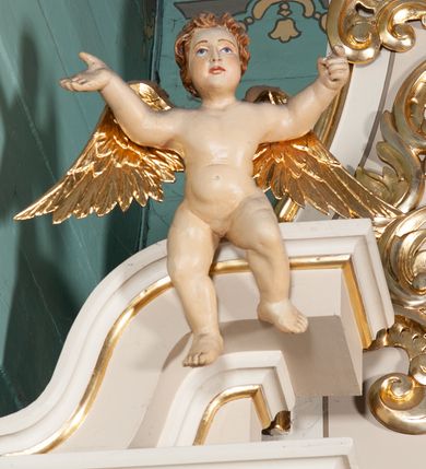 Zdjęcie nr 4: Ołtarz architektoniczny, przyścienny, jednoosiowy, jednokondygnacyjny ze zwieńczeniem. Nastawa umieszczona jest na skrzyniowej mensie z kamiennym blatem. Antepedium ozdabia okrągła płycina z otaczającym monogram IHS czteroliściem wpisanym w koło, flankowana przez dwie kwadratowe płyciny, których wewnętrzne krawędzie są wklęsłe. Boczne ścianki mensy ozdobione są prostokątną płyciną. Nastawa flankowana ustawionymi na wysuniętych partiach cokołu kolumnami dźwigającymi pełne belkowanie wyłamane na ich osiach i podtrzymujące fragmenty urwanego przyczółka. Cokół jest dekorowany prostokątnymi płycinami, na osiach zewnętrznych dodatkowo wypełnionymi ornamentem małżowinowym i rocaille’owym. W polu centralnym nisza zamknięta od góry łukiem spłaszczonym, w której znajduje się wizerunek św. Józefa z małym Jezusem. Poniżej niszy trzy płyciny z symetryczną dekoracją rocaille’ową, powyżej wstęga z napisem „BÓG UWIELBIONY I BŁ[OGOSŁAWIONY]” ujęta liśćmi. Kondygnacja jest z prawej strony ujęta uszakiem skomponowanym z ażurowej wici akantowej. Pole zwieńczenia wypełnia rama w kształcie stojącego owalu z wizerunkiem św. Stanisława Kostki, otoczona ornamentem inspirowanym małżowinowym. Powyżej muszla palmetowa, a na urwanych fragmentach przyczółka posadowiono anioły. 
Struktura polichromowana na kremowo ze złoconą i srebrzoną ornamentyką oraz detalami architektonicznymi.