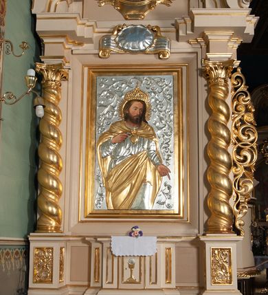 Zdjęcie nr 2: Ołtarz przyścienny, architektoniczny, na cokole. Mensa drewniana. Antepedium w kształcie leżącego prostokąta, ujęte profilami, z okrągłą plakietą z monogramem IHS po środku. Na mensie tabernakulum na rzucie prostokąta z uskokiem, dekorowane płycinami w kształcie stojących prostokątów, z drzwiczkami ozdabianymi aplikowanym kielichem z hostią. Nastawa jednoosiowa, jednokondygnacyjna ze zwieńczeniem. Oś środkowa flankowana parą kręconych kolumn o kapitelach kompozytowych ustawionych przed licem, na tle pilastrów. Podpory dźwigają pełne, wyłamane belkowanie oraz odpowiadający ich ułożeniu przerwany przyczółek. Zwieńczenie ujęte w spływy, zamknięte łukiem kotarowym dwudzielnym. Cokoły kolumn dekorowane plakietami z ornamentem roślinnym. W polu środkowym obraz we wnęce z przedstawieniem Najświętszego Serca Jezusa w profilowanej ramie, w formie stojącego prostokąta, powyżej puste pole kartusza. Pierwsza kondygnacja ujęta z prawej strony uszakiem utworzonym z wici roślinnej. Na przerwanym przyczółku spoczywa para aniołów. W zwieńczeniu profilowana owalna rama z obrazem św. Józefa powyżej kartusza i wśród kłosów zbóż, spływy ujmujące zwieńczenie dekorują liście. 
Struktura polichromowana na kremowo ze złoconą i srebrzoną ornamentyką oraz detalami architektonicznymi.