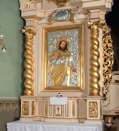 Zdjęcie nr 3: Ołtarz przyścienny, architektoniczny, na cokole. Mensa drewniana. Antepedium w kształcie leżącego prostokąta, ujęte profilami, z okrągłą plakietą z monogramem IHS po środku. Na mensie tabernakulum na rzucie prostokąta z uskokiem, dekorowane płycinami w kształcie stojących prostokątów, z drzwiczkami ozdabianymi aplikowanym kielichem z hostią. Nastawa jednoosiowa, jednokondygnacyjna ze zwieńczeniem. Oś środkowa flankowana parą kręconych kolumn o kapitelach kompozytowych ustawionych przed licem, na tle pilastrów. Podpory dźwigają pełne, wyłamane belkowanie oraz odpowiadający ich ułożeniu przerwany przyczółek. Zwieńczenie ujęte w spływy, zamknięte łukiem kotarowym dwudzielnym. Cokoły kolumn dekorowane plakietami z ornamentem roślinnym. W polu środkowym obraz we wnęce z przedstawieniem Najświętszego Serca Jezusa w profilowanej ramie, w formie stojącego prostokąta, powyżej puste pole kartusza. Pierwsza kondygnacja ujęta z prawej strony uszakiem utworzonym z wici roślinnej. Na przerwanym przyczółku spoczywa para aniołów. W zwieńczeniu profilowana owalna rama z obrazem św. Józefa powyżej kartusza i wśród kłosów zbóż, spływy ujmujące zwieńczenie dekorują liście. 
Struktura polichromowana na kremowo ze złoconą i srebrzoną ornamentyką oraz detalami architektonicznymi.