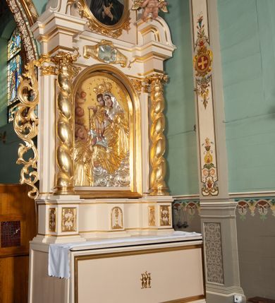 Zdjęcie nr 12: Ołtarz przyścienny, architektoniczny, na cokole. Mensa drewniana. Antepedium w kształcie leżącego prostokąta, wypełnione płyciną, z monogramem maryjnym pośrodku. Na mensie tabernakulum w na rzucie trapezu, z drzwiczkami w kształcie stojącego prostokąta zamkniętego półkoliście dekorowanymi aplikowanym kielichem z hostią. Nastawa ołtarzowa jednoosiowa, jednokondygnacyjna ze zwieńczeniem. Oś środkowa flankowana parą kręconych kolumn o kapitelach kompozytowych ustawionych przed licem, na tle pilastrów. Podpory dźwigają pełne, wyłamane belkowanie oraz odpowiadający ich ułożeniu przerwany przyczółek. Zwieńczenie ujęte w spływy, zamknięte łukiem kotarowym dwudzielnym spiętym muszlą palmetową. Cokoły kolumn dekorowane plakietami z ornamentem roślinnym. W polu środkowym obraz we wnęce z przedstawieniem Matki Boskiej Różańcowej w profilowanej ramie, w formie stojącego prostokąta zamkniętego półkoliście, powyżej puste pole kartusza. Pierwsza kondygnacja ujęta z lewej strony uszakiem utworzonym z wici roślinnej. Na przerwanym przyczółku spoczywa para aniołków. W zwieńczeniu profilowana owalna rama z obrazem św. Andrzeja Boboli otoczona od dołu kłosami zbóż. 
Struktura polichromowana na kremowo ze złoconą i srebrzoną ornamentyką oraz detalami architektonicznymi.
