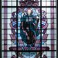 Zdjęcie nr 1: Witraż w formie stojącego prostokąta zwieńczonego łukiem trójwklęsłym. W polu wizerunek św. Andrzeja Boboli, ukazanego frontalnie, całopostaciowo, z laską pasterską w lewej dłoni i krzyżem w uniesionej prawej. Święty jest ubrany w habit oraz rozwiewający się płaszcz w odcieniach koloru bordowego i ciemnozielonego. Wizerunek ujęty blado- i ciemnoliliowymi polami o nieregularnym kształcie oraz stylizowanymi bordowymi wstęgami. Całość przedstawienia na tle pól z niebarwionego szkła. Wzdłuż dłuższych boków witraża i łuku bordiura w postaci bordowej wstęgi. U stóp świętego inskrypcja „ŚW(IĘTY) ANDRZEJU / MÓDL SIĘ / ZA NAMI” i niżej „OFIAROWAŁA / GROMADA ZELCZYNA / 1953”. Witraż o intensywnych kolorach z przewagą bordowego. 