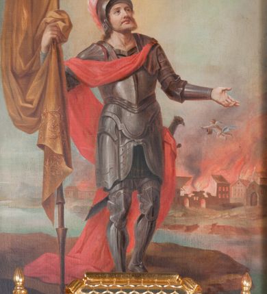 Zdjęcie nr 17: Ołtarz przyścienny, architektoniczny, na cokole, z bramkami. Nastawa jednoosiowa, jednokondygnacyjna ze zwieńczeniem. Mensa murowana, blat kamienny. Antepedium w kształcie leżącego prostokąta ujętego parami kolumn o gładkich trzonach i głowicach kompozytowych, podtrzymujących belkowanie z parami tryglifów. Belkowanie nad częścią środkową ucięte łukowato. W polu środkowym płaskorzeźbiona scena z przedstawieniem Świętej Rodziny. Postać św. Józefa półleżąca, zwrócona profilem w prawo, w stronę Matki Boskiej. Siedząca Maria skierowana w trzech czwartych w prawo, trzyma na kolanach poruszone Dzieciątko. Oś środkowa flankowana parą opilastrowanych filarów i kolumn o kapitelach kompozytowych, ustawionych przed licem ołtarza pod kątem. Podpory dźwigają pełne, wyłamane belkowanie oraz odpowiadający ich ułożeniu przerwany przyczółek. Zwieńczenie ujęte w spływy, zamknięte łukiem nadwieszonym. Cokoły kolumn dekorowane rocaille’em. W polu środkowym obraz we wnęce z przedstawieniem Matki Boskiej z Dzieciątkiem zasłaniany wizerunkiem św. Floriana w profilowanej ramie, w formie stojącego prostokąta zamkniętego dwoma, zwróconymi naprzeciwlegle stykającymi się spływami wolutowymi oraz rocaille’owym kartuszem z inskrypcją „POD TWOJĄ OBRONĘ”. Pierwsza kondygnacja ujęta uszakami utworzonymi z ornamentu rocaille’owego, ażurowej kratki regencyjnej i ornamentu roślinnego w formie kwiatów. Na bramkach ustawiono figury św. Wojciecha i św. Stanisława. Na przerwanym przyczółku spoczywa para adorujących aniołów. W zwieńczeniu profilowana rama powtarzająca jego formę z obrazem św. Antoniego Padewskiego zamknięta rocaille’em. Całość ujęta w spływy z ornamentu roślinnego. Struktura polichromowana na kremowo ze złoconą i srebrzoną ornamentyką oraz detalami architektonicznymi.