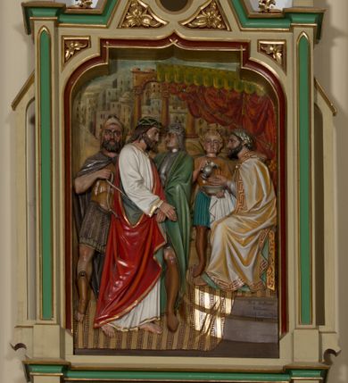 Zdjęcie nr 1: Czternaście płaskorzeźbionych, polichromowanych stacji drogi krzyżowej ukazanych na tle malowanego pejzażu. Przedstawienia ujęte w neogotyckie, architektoniczne ramy zamknięte wimpergą z żabkami, zwieńczoną  kwiatonem z krzyżem, pośrodku wimpergi czterolistna płycina z numerem stacji. Wnęka na płaskorzeźbę zamknięta łukiem dwuramiennym. Partia cokołowa ujęta od dołu podwieszeniem z rozetką. Polichromia ram w odcieniu kremowym, zielonym i ciemnoczerwonym z pozłacanym detalem. Sceny wielofigurowe z Chrystusem w centrum. Chrystus na większości przedstawień jest ubrany w długą, białą tunikę z pozłacaną lamówką i czerwony płaszcz z błękitną podszewką. Twarz owalna okolona ciemnymi włosami i ciemnym zarostem. W tle pejzaż z elementami architektury. Na stacji pierwszej, w prawym dolnym rogu napis „Ferd(inand) Stuflesser / Bildabauer / S(ank)t Ulrich Gröden Tirol / 1903”.