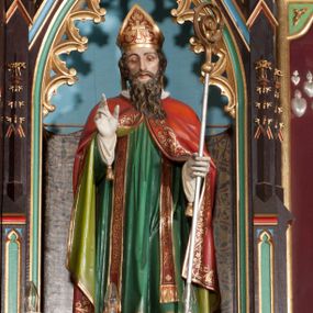 Zdjęcie nr 1: Rzeźba pełnoplastyczna, ustawiona frontalnie na niskim cokole. Święty Stanisław ukazany w pozycji stojącej z prawą ręką uniesioną w geście błogosławieństwa, w lewej trzyma pastorał. Ma podłużną twarz o wyraźnie zaznaczonych kościach policzkowych, długi i wąski nos oraz długą, brązową brodę. Ubrany jest w długą, białą albę z geometrycznym wzorem u dołu, zieloną tunicele, czerwoną kapę z oliwkowo-zieloną podszewką, stułę przewieszoną przez piersi, złotą infułę oraz białe rękawice z jednym chwostem na brzegu. Wszystkie szaty zdobione są na brzegach złoconą lamówką. Polichromia w odsłoniętych partiach ciała naturalistyczna.