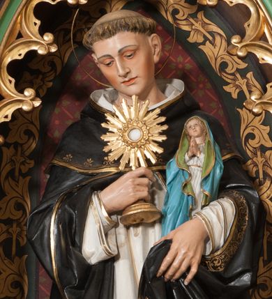 Zdjęcie nr 1: Rzeźba pełnoplastyczna, stojąca frontalnie w delikatnym kontrapoście na niskim, szarym cokole. Święty Jacek w prawej dłoni trzyma monstrancję, a w lewej figurę Matki Boskiej, głowę przechyla delikatnie na prawe ramię. Ma idealizowane rysy twarzy, lekko przymknięte oczy, długi i wąski nos, zarumienione policzki, na głowie tonsurę, a wokół niej okrągły nimb. Ubrany jest w biały habit ze szkaplerzem i czarny płaszcz dominikański, które na brzegach obwiedzione są złotą lamówką. Polichromia w odsłoniętych partiach ciała naturalistyczna.

