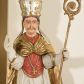 Zdjęcie nr 1: Rzeźba ścięta z tyłu, przedstawia św. Stanisława. Święty ukazany w postawie stojącej na niskim cokole, frontalnie, w statycznej pozie, z rękami wyciągniętymi do przodu i odwiedzionymi delikatnie na boki: prawą wykonuje gest błogosławieństwa, w lewej trzyma pastorał. Ma szeroką twarz, z długim i prostym nosem, wzrokiem skierowanym na wprost oraz wąsy. Włosy krótkie, kędzierzawe, ciemnobrązowe. Święty jest ubrany jest w czerwoną sutannę, białą rokietę zdobioną na brzegach złoceniem, czerwony mucet, złotą kapę, spiętą na piersiach broszą, białe rękawice, jasnobrązowe buty oraz srebrzoną infułę, zdobioną złoconymi kaboszonami, rautami, motywami w kształcie litery „S” oraz czteropłatkowymi kwiatami. Na piersi ma zawieszony złocony krzyż pektoralny. Obok jego prawej nogi znajduje się mała klęcząca postać Piotrowina ze złożonymi rękami, ubranego w białą, długą suknię i zielony płaszcz. Polichromia w odsłoniętych partiach ciała jest naturalistyczna. Cokół jasnozielony, z przodu czarno malowany napis: „ŚW(IĘTY) STANISŁAW.” 




