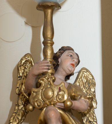 Zdjęcie nr 2: Rzeźby pełnoplastyczne, złocone i polichromowane, przedstawiające figury klęczących aniołów w dynamicznych pozach podtrzymujących świeczniki, ustawione na niskich cokołach. Twarze owalne, pełne o ekspresyjnym wyrazie: uniesiony ku górze wzrok, półotwarte usta. Włosy ciemnobrązowe, półdługie, falowane. Anioły ubrane są w bogato drapowane szaty z długimi rękawami. Partie karnacji polichromowane, szaty, skrzydła oraz trzony świeczników złocone.