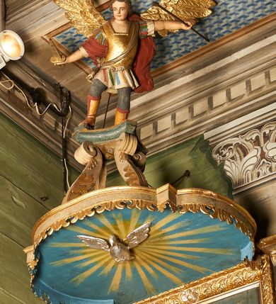 Zdjęcie nr 4: Ambona wisząca, przyścienna. Kosz na planie ośmioboku, na ściankach arkady z malowanymi przedstawieniami św. Walentego, św. Wincentego, św. Jana Nepomucena i bł. Jana Kanonika. Ścianki wydzielone kolumnami kompozytowymi na cokole, dźwigającymi pełne belkowanie wyłamane na ich osi. Parapet w formie silnie wystającego, profilowanego gzymsu. Z prawej strony dostawione jednobiegowe schody z barierką zwieńczoną profilowanym gzymsem. Zaplecek wysoki, ujęty pilastrami dźwiganymi przez konsolki dekorowane liściem; w polu obraz św. Grzegorza Wielkiego. Baldachim na planie trójliścia z lambrekinem z ornamentu roślinnego; utworzony z czterech pałąków dekorowanych akantem, podtrzymujących cokół dla figury św. Michała Archanioła. Figura zwrócona frontalnie, z prawą nogą opartą na fragmencie skały. W lewej ręce trzyma włócznię, w prawej miecz. Ubrany w zbroję, z szeroko rozłożonymi skrzydłami. Na podniebieniu gołębica Ducha Świętego na tle glorii promienistej. Ambona marmoryzowana w tonacji zielono-niebieskiej ze złoconymi detalami i ornamentami.
św. Jana Kantego, św. Jana Nepomucena, św. Walentego i św. Wincentego

św. grzegorz unoszący się nad rzymem