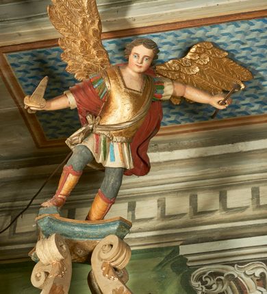 Zdjęcie nr 6: Ambona wisząca, przyścienna. Kosz na planie ośmioboku, na ściankach arkady z malowanymi przedstawieniami św. Walentego, św. Wincentego, św. Jana Nepomucena i bł. Jana Kanonika. Ścianki wydzielone kolumnami kompozytowymi na cokole, dźwigającymi pełne belkowanie wyłamane na ich osi. Parapet w formie silnie wystającego, profilowanego gzymsu. Z prawej strony dostawione jednobiegowe schody z barierką zwieńczoną profilowanym gzymsem. Zaplecek wysoki, ujęty pilastrami dźwiganymi przez konsolki dekorowane liściem; w polu obraz św. Grzegorza Wielkiego. Baldachim na planie trójliścia z lambrekinem z ornamentu roślinnego; utworzony z czterech pałąków dekorowanych akantem, podtrzymujących cokół dla figury św. Michała Archanioła. Figura zwrócona frontalnie, z prawą nogą opartą na fragmencie skały. W lewej ręce trzyma włócznię, w prawej miecz. Ubrany w zbroję, z szeroko rozłożonymi skrzydłami. Na podniebieniu gołębica Ducha Świętego na tle glorii promienistej. Ambona marmoryzowana w tonacji zielono-niebieskiej ze złoconymi detalami i ornamentami.
św. Jana Kantego, św. Jana Nepomucena, św. Walentego i św. Wincentego

św. grzegorz unoszący się nad rzymem