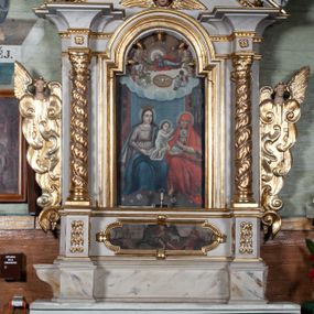 Zdjęcie nr 1: Ołtarz przyścienny, architektoniczny, jednokondygnacyjny ze zwieńczeniem i uszakami. Mensa drewniana, prostopadłościenna, marmoryzowana. W predelli obraz w kształcie spłaszczonego owalu z przedstawieniem św. Jana Chrzciciela. Nastawa na wysokim cokole ujęta złoconymi, kręconymi kolumnami o korynckich kapitelach. Kolumny dźwigają fragmenty przełamanego i przerwanego w osi ołtarza belkowania. Kondygnacja pierwsza ujęta uszami utworzonymi ze złoconych wolut i małżowin zwieńczonych główkami anielskimi ze skrzydłami. W centrum obraz św. Anny Samotrzeć w kształcie stojącego prostokąta zamkniętego łukiem nadwieszonym. W podłuczu złocone szyszki; powyżej uskrzydlona główka anielska. Zwieńczenie w formie trójkątnego przyczółka dekorowanego ząbkowaniem; część środkowa wyniesiona, zamknięta półkoliście. Na nim dwie postaci półleżących aniołów w białych szatach. W zwieńczeniu obraz Nawiedzenia w kształcie stojącego prostokąta o ściętych górnych narożach. 
Struktura ołtarza malowana na biało; ornamenty oraz elementy architektoniczne złocone; twarze figur polichromowane.
