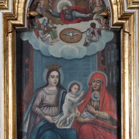 Zdjęcie nr 1: Obraz w kształcie stojącego prostokąta zamkniętego łukiem nadwieszonym, w złoconej i profilowanej ramie. W centrum kompozycji, u dołu przedstawienie św. Anny Samotrzeć. Maria z lewej i św. Anna z prawej siedzą obok siebie, na kolanach Marii stoi mały Jezus, który czyni gest błogosławieństwa w stronę św. Anny. Anna lewą ręką podaje mu owoc, w prawej trzyma otwartą książkę, patrzy na Jezusa. Maria jest ubrana w jasnofioletową suknię przewiązaną w pasie oraz ciemnobłękitny płaszcz z jasnym podbiciem, na głowie ma otwartą koronę. Święta Anna ma na sobie zielonkawą suknię oraz obszerny czerwony płaszcz narzucony na głowę, osłaniający ramiona oraz nogi. Jezus w białej, długiej, przylegającej do ciała tunice. Wszyscy mają nimby wokół głów. Pod ich stopami goła ziemia, na której widać kwitnące kwiaty. W górnej części kompozycji przedstawienie Boga Ojca i gołębicy Ducha Świętego w obłokach. Bóg jest widoczny do połowy ciała, ma rozłożone ręce i spogląda w dół, na siedzącą poniżej grupę. Ma długie siwe włosy oraz brodę, jest ubrany w niebieskawą tunikę i czerwony płaszcz, głowę rozświetla mu szeroki nimb, wokół którego unoszą się cztery uskrzydlone główki anielskie. Poniżej Boga Ojca gołębica z rozpostartymi skrzydłami w świetlistym otoku. Po ich bokach siedzą anioły grające na instrumentach.
 Kolorystyka ciemna, ciepła.