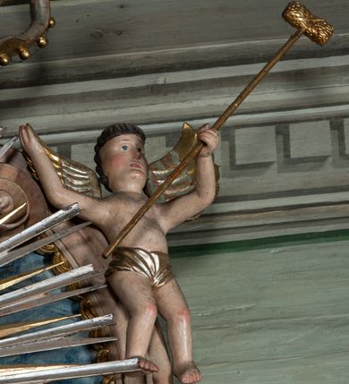 Zdjęcie nr 5: Ołtarz przyścienny, architektoniczny, jednoosiowy, jednokondygnacyjny ze zwieńczeniem i ażurowymi uszakami o falistym brzegu. Mensa w typie sarkofagowym, profilowana, z kamiennym portatylem. Retabulum wklęsłe, ujęte parą kolumn kompozytowych ustawionych na kostkowych cokołach z rozetkami, wspierających belkowanie wyłamujące się ponad nimi, zamknięte wydatnym, profilowanym gzymsem. Fryz dekorowany rozetkami. Nad belkowaniem na osiach kolumn ustawione wazony o marmoryzowanej i żłobionej powierzchni. W polu środkowym głęboka wnęka zamknięta wielobocznie, w której rzeźbiony krucyfiks, po jego bokach malowane postacie Matki Boskiej i Św. Jana na tle pejzażu z architekturą. Zwieńczenie półkoliste ujęte spływami wolutowymi, na których rzeźby aniołków z arma Christi (aniołek po prawej z włócznią, po lewej zaś z gąbką). Pośrodku zwieńczenia owalny obraz z przedstawieniem św. Wojciecha ujęty ramą uformowaną z obłoków z odchodzącymi promieniami. Nad zwieńczeniem rzeźbiona, złocona korona zamknięta. Struktura ołtarza polichromowana, marmoryzowana na odcień niebieski, antepedium z polem marmoryzowanym na kolor beżowy. 