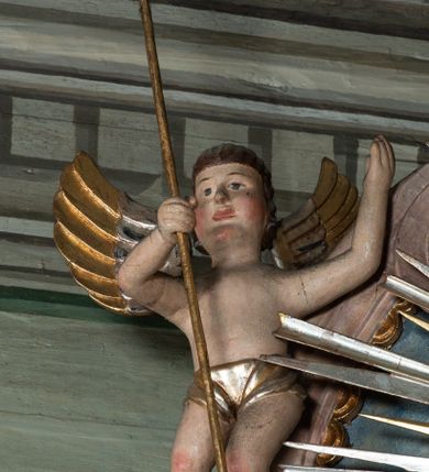 Zdjęcie nr 3: Ołtarz przyścienny, architektoniczny, jednoosiowy, jednokondygnacyjny ze zwieńczeniem i ażurowymi uszakami o falistym brzegu. Mensa w typie sarkofagowym, profilowana, z kamiennym portatylem. Retabulum wklęsłe, ujęte parą kolumn kompozytowych ustawionych na kostkowych cokołach z rozetkami, wspierających belkowanie wyłamujące się ponad nimi, zamknięte wydatnym, profilowanym gzymsem. Fryz dekorowany rozetkami. Nad belkowaniem na osiach kolumn ustawione wazony o marmoryzowanej i żłobionej powierzchni. W polu środkowym głęboka wnęka zamknięta wielobocznie, w której rzeźbiony krucyfiks, po jego bokach malowane postacie Matki Boskiej i Św. Jana na tle pejzażu z architekturą. Zwieńczenie półkoliste ujęte spływami wolutowymi, na których rzeźby aniołków z arma Christi (aniołek po prawej z włócznią, po lewej zaś z gąbką). Pośrodku zwieńczenia owalny obraz z przedstawieniem św. Wojciecha ujęty ramą uformowaną z obłoków z odchodzącymi promieniami. Nad zwieńczeniem rzeźbiona, złocona korona zamknięta. Struktura ołtarza polichromowana, marmoryzowana na odcień niebieski, antepedium z polem marmoryzowanym na kolor beżowy. 