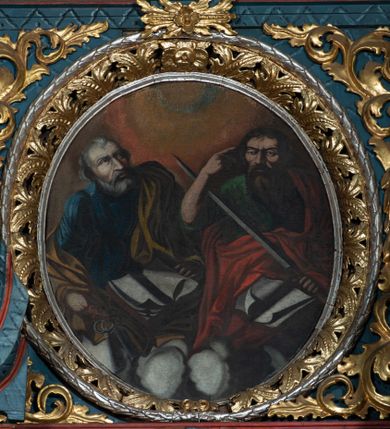 Zdjęcie nr 1: Obraz w formie owalu, w centrum dwie półpostacie świętych na obłokach. Po prawej św. Paweł, zwrócony w trzech czwartych w prawo. W lewej ręce trzyma miecz zwrócony ku górze, prawą unosi, wskazując głowę. Twarz ascetyczna, o ściągniętych brwiach, okolona długą brodą opadającą na pierś. Włosy krótkie, ciemne. Święty jest ubrany w zieloną tunikę oraz przerzucony diagonalnie czerwony płaszcz. Na jego kolanach księga. Po lewej stronie św. Piotr zwrócony w trzech czwartych w lewą stronę,  z głową uniesioną ku górze. W prawej ręce trzyma klucze, lewą przytrzymuje leżącą przed nim księgę. Twarz podłużna o starczych rysach, okolona siwą brodą; włosy krótkie, siwe. Ubrany jest w granatową tunikę oraz żółty płaszcz przerzucony przez lewe ramię. Tło w formie poświaty w układzie koncentrycznych kręgów. Kolorystyka kontrastowa, intensywna, o silnym światłocieniu.