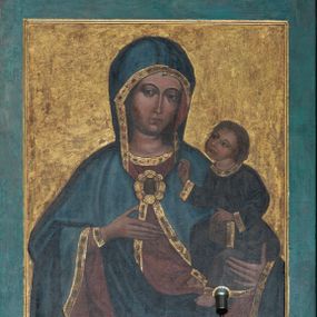 Zdjęcie nr 1: Obraz w formie stojącego prostokąta, w błękitnej ramie. W centrum półpostać Matki Boskiej zwróconej na wprost. Maria lewą ręką podtrzymuje Dzieciątko, prawą uniesioną na wysokość piersi wskazuje na nie. Twarz ma owalną, o wyraźnych rysach oczu i brwi, długim, wąskim nosie i małych ustach. Matka Boska jest ubrana w czerwoną suknię spodnią ze złoconą lamówką oraz granatowy płaszcz, podbity czerwienią, zdobiony złoconą lamówką, okrywający ramiona i głowę oraz spięty na piersi fibulą w formie rozety. Dzieciątko zwrócone w trzech czwartych w prawo, z głową uniesioną do góry. Lewą ręką podtrzymuje na kolanach księgę, prawą unosi w geście błogosławieństwa. Twarz ma okrągłą, o wyraźnych rysach, dużych oczach, wąskim nosie i małych ustach. Włosy jasne, krótkie, kręcone. Jezus jest ubrany w szarą tunikę przepasaną w talii ze złoconymi lamówkami. Tło jednolite złocone. Kolorystyka kontrastowa, wyrazista; silny światłocień.