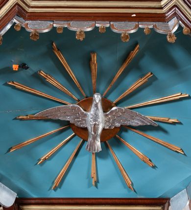 Zdjęcie nr 3: Ambona zawieszona w arkadzie tęczy, dostępna jednobiegowymi schodami od wschodu, od strony wejścia do zakrystii. Kosz na rzucie ośmioboku, opięty smukłymi kolumienkami o gładkich trzonach i kompozytowych kapitelach, ustawionymi występujących wybrzuszonych postumentach i wspierającymi gzyms występujący na nimi. Boki kosza na przemian gładkie i ozdobione nałożonymi rzeźbionymi motywami roślinnymi. Kosz nadwieszony na konsoli w kształcie spłaszczonego ostrosłupa. Zaplecek prostokątny, z prostokątną zamkniętą półkoliście płyciną, w której w górnej części litery IHS z krzyżem, otoczony promieniami. Baldachim powtarza rzut i podziały kosza, ozdobiomy lambrekinem, nakryty spłaszczonym ostrosłupem zwieńczonym prostym krzyżykiem. Na podniebiu rzeźbiona Gołębica Ducha Świętego wśród promieni. Struktura pomalowana na brązowo, podniebie baldachimu w kolorze bękitnym, ornamenty i detale architektoniczne złocone. 