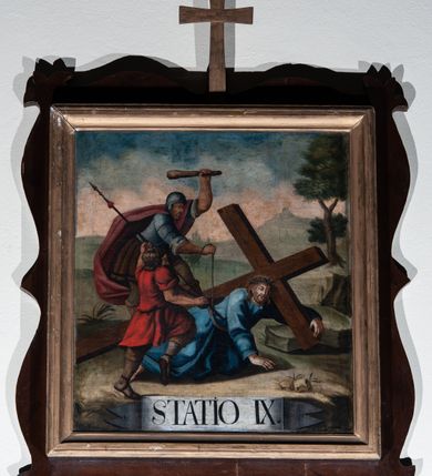 Zdjęcie nr 13: Czternaście stacji Drogi Krzyżowej w kształcie prostokąta zbliżonego do kwadratu, w profilowanych ramkach z krzyżykiem łacińskim pośrodku listwy górnej. Sceny wielofigurowe, o otwartej kompozycji, na tle monumentalnej architektury lub krajobrazu. U dołu białe banderole z oznaczeniem numeru stacji.