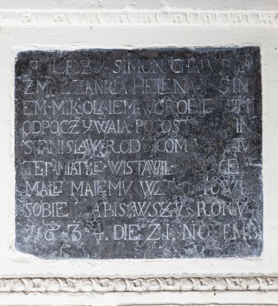 Zdjęcie nr 1: Płyta w kształcie leżącego prostokąta, w profilowanej opasce tynkowej dekorowanej kimationem. Inskrypcja majuskułowa w języku polskim i zapisem daty po łacinie: TU LEŻY SIMON CHALUBKA / Z MAŁŻANKA HELENA Y SIN/EM MIKOLAIEM W GROBIE TYM / ODPOCZYWAIA POZOSTALY SIN / STANISLAW RODZICOM Y BRATV / TE PAMIATKE WISTAWIŁ MIEISCE / MAŁE MALEMU WZROSTOWI / SOBIE ZABISAWSZY ROKV / 1634. DIE 2I. NOVEMB(RIS).
