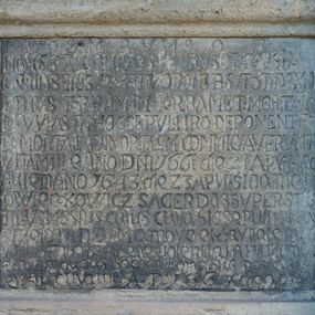 Zdjęcie nr 1: Kamienna płyta epitafium w kształcie stojącego prostokąta, z kutą inskrypcją, w kamiennym profilowanym obramieniu. Inskrypcja majuskułowa, w języku łacińskim, z datami śmierci małżonków i datą sprawienia pomnika.