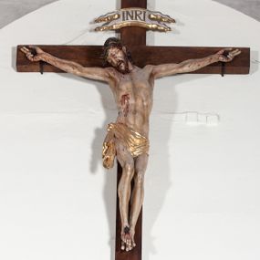 Zdjęcie nr 1: Chrystus rozpięty na krzyżu z ułożonymi niemal poziomo, szeroko rozłożonymi rękami, z ugiętą w kolanie prawą nogą, lewą niemal wyprostowaną, stopami założonymi prawa na lewą i przebitymi jednym gwoździem, z głową skłonioną na prawy bark. Twarz pociągła, z długim nosem i wpółotwartymi ustami, okolona zarostem i długimi spływającymi na kark włosami, spod których widać lewe ucho. Budowa anatomiczna i muskulatura silnie podkreślona naprężeniem ciała. Karnacja w odcieniu naturalnym z zaznaczonymi śladami męki. Rana w prawym boku. Wokół bioder perizonium zawiązane na prawym koku w węzeł, ze zwisem tkaniny przy prawym udzie. Nad głową Chrystusa poziomo ułożony titulus z końcami wyciętym w jaskółczy ogon, z literami INRI. Krzyż malowany na kolor brązowy, karnacja i włosy Chrystusa w kolorze naturalnym, perizonium srebrzone i złocone, titulus biały ze złoconymi krawędziami.
