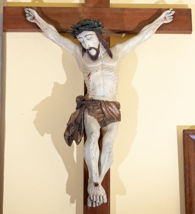 Zdjęcie nr 1: Chrystus rozpięty na krzyżu w lekkim zwisie ciała, z ukośnie ułożonymi rękami, z niemal wyprostowanymi nogami, stopami założonymi prawa na lewą i przebitymi jednym gwoździem, z głową przechyloną na prawy bark. Proporcje ciała zaburzone: duża głowa, krótki tors, chude ręce z drobnymi dłońmi, nogi muskularne z dużymi stopami. Twarz trójkątna, z zamkniętymi oczami, okolona krótkim zarostem i spływającymi na barki włosami. Na włosy nałożona korona cierniowa. Rana w prawym boku.  Wokół bioder podwiązane sznurem perizonium ze zwisem tkaniny przy prawym udzie. Nad głową Chrystusa ułożony poziomo titulus z wyciętymi w jaskółczy ogon końcami, z literami IN RI. Krzyż w kolorze brązowym, karnacja ciała blada, włosy ciemne, perizonium złocone (pociemniałe), titulus biały.