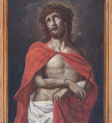 Zdjęcie nr 1: Obraz w kształcie stojącego prostokąta, w profilowanej ramie, z przedstawieniem Chrystusa w typie Ecce Homo, ukazanego w trzech czwartych postaci, zwróconego lekko w lewo, z głową lekko przechyloną na prawy bark i wzrokiem skierowanym ku górze. Twarz pociągła, o głęboko osadzonych oczach, długim nosie, okolona krótkim zarostem i opadającymi na barki włosami. Na głowie korona cierniowa upleciona z drobnych kolczastych gałązek. Wokół głowy nimb ze świetlistych promieni. Ręce ugięte w łokciach, z dłońmi skrępowanymi w nadgarstkach sznurem, ułożonymi na wysokości pasa. Palcami prawej dłoni Chrystus trzyma trzcinę. Lewą ręką podtrzymuje połę płaszcza. Biodra osłonięte białym perizonium. Na ramiona narzucony czerwony płaszcz, spięty pod szyją i spływający d dół Lewą dłonią Chrystus podtrzymuje jego lewą połę zarzuconą na przód postaci. Tło ciemne, monochromatyczne.      
