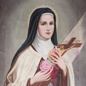 Zdjęcie nr 1: Obraz w kształcie stojącego prostokąta, w profilowanej, złoconej ramie dekorowanej ornamentem roślinnym z masy gipsowej. Przedstawienie św. Teresy od Dzieciątka Jezus, ukazanej w półpostaci, zwróconej w trzech czwartych w lewo, ze wzrokiem skierowanym do widza. Dłońmi o cienkich palcach podtrzymuje na wysokości piersi ułożony diagonalnie krzyż ozdobiony różami, na który pada ukośnie z góry smuga światła. Ubrana w habit karmelitański: brązową tunikę, biały płaszcz chórowy i czarny welon. Tło ciemne, monochromatyczne, rozjaśnione wokół głowy świętej. 