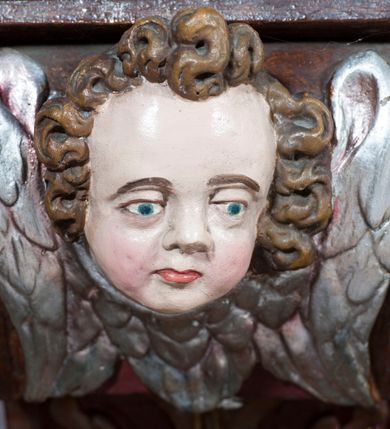 Zdjęcie nr 6: Ołtarz architektoniczny, jednoosiowy, z wydzieloną predellą, jednokondygnacyjny, ze zwieńczeniem. Mensa drewniana na skrzyniowej prostopadłościennej tumbie. Antependium w prostokątnej profilowanej ramie zdobione trzema płycinami, w których pośrodku płaskorzeźbione przedstawienie Chrystusa upadającego pod krzyżem, po bokach motywy serca. Nastawa ujęta kwadratowymi w rzucie filarami przyściennymi o kanelowanych trzonach, z kompozytowymi kapitelami, dźwigającymi występującymi nad nimi uproszczone belkowanie i profilowany gzyms, przerwany nad polem środkowym. Na tle filarów ustawione na konsolach rzeźby: Matka Boska Bolesna po lewej i św. Jan Ewangelista po prawej stronie. W polu środkowym barokowy obraz z przedstawieniem Ukrzyżowania w ozdobnej ramie. W przyłuczach ramy uskrzydlone główki aniołków. Poniżej obrazu nałożony motyw kielicha, po bokach dwie banderole z inskrypcją: BŁOGOSŁAWIONY KTÓRY / IDZIE W IMIĘ PAŃSKIE. Zwieńczenie w kształcie aedikuli o wklęsłych bokach, zamkniętej łukiem półkolistym nadwieszonym. W polu zwieńczenia obraz ukazujący św. Rozalię. Na gzymsie koronującym rzeźbione przedstawienie Boga Ojca oraz Gołębica Ducha Świętego. Poniżej obrazu medalion ze złoconymi literami: IHS. W osiach podpór dwa uskrzydlone anioły trzymające Arma Christi (trzcinę z gąbką i włócznię). Nastawa flankowana ażurowymi, płasko rzeźbionymi uszami w formie wici winnej latorośli z kiściami gron i liśćmi.  Struktura malowana na kolor brązowy, rzeźby, detale architektoniczne i ornamenty złocone lub srebrzone, część laserowana.