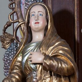 Zdjęcie nr 1: Rzeźba pełnoplastyczna, przyścienna; przedstawienie Matki Boskiej Bolesnej ukazanej w całej postaci, stojącej w lekkim kontrapoście, z prawą nogą ugiętą w kolanie, zwróconej lekko w lewo i twarzą skierowaną ku górze. Prawa ręka odwiedziona od ciała, wyciągnięta do przodu, lewa ugięta w łokciu, z dłonią złożoną na piersi. Twarz pełna, o jasnej karnacji, z wysokim czołem, regularnymi łukami brwiowymi, drobnymi ustami i pełnym podbródkiem. Ubrana w suknię z długimi rękawami, przewiązaną w pasie, układającą się drobnymi pionowymi fałdami, oraz płaszcz, który okrywa głowę, spływa na ramiona i osłania przód postaci.