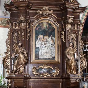 Zdjęcie nr 1: Ołtarz architektoniczny, jednokondygnacyjny, jednoosiowy ze zwieńczeniem. Antepedium z płaskorzeźbionym krzyżem ujętym wolutami z motywami lilii. Nastawę ujmują ukośnie ustawione zwielokrotnione  pilastry z konsolami, na których stoją figury. Pilastry podtrzymują belkowanie, które nad zewnętrznymi pilastrami jest lekko wklęsłe, nad wewnętrznymi zwieńczone falującymi naczółkami, a nad osią środkową  z lekko wybrzuszonym architrawem. Zwieńczenie o lekko wklęsłych bokach zamknięte profilowanym gzymsem w formie łuku nadwieszonego. W polu środkowym wnęka w kształcie stojącego prostokąta zakończonego łukiem odcinkowym, nadwieszonym, w niej obraz &quot;Św. Anna Samotrzeć&quot; i &quot;Męczeństwo św. Sebastiana&quot; na zasuwie. Pole obrazowe w zwieńczeniu powtarza jego kształt, wypełnione wizerunkiem św. Floriana. W partii predelli wkomponowano fantazyjny kartusz z obrazem przedstawiającym hołd Trzech Króli. Na dekorację ornamentalną składają się motywy rocaille&#039;owe na pilastrach, uszy ujmujące nastawę z rocaille&#039;ami w części wypełnionymi kratką regencyjną, kartusz w partii belkowania oraz drobne motywy roślinne i rokokowe w partii zwieńczenia., 

