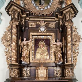 Zdjęcie nr 1: Ołtarz architektoniczny, jednoosiowy, z wydzieloną predellą, jednokondygnacyjny, ze zwieńczeniem. Mensa na prostopadłościennej, skrzyniowej tumbie z antependium ozdobionym prostokątną płyciną ze złoconym medalionem z ulistnioną gałązką pośrodku. Nastawa ujęta ustawionymi ukośnie kolumnami o skręconych trzonach oplecionych girlandą z liści i owoców, na cokołach, z kompozytowymi kapitelami, ustawionymi na dwustrefowych prostopadłościennych postumentach. Kolumny wspierają występujące nad nimi uproszczone belkowanie i profilowany gzyms, cofnięte nad polem środkowym. W polu nastawy prostokątna nisza ujęta ozdobną ramą, w której obraz Matki Boskiej z Dzieciątkiem oraz na zasuwie obraz Matki Boskiej Różańcowej ze św. Dominikiem i św. Katarzyną ze Sieny. Po bokach obrazu rzeźby dwóch uskrzydlonych aniołów, umieszczone na konsolach. Ponad obrazem pośrodku dwie główki aniołków ze skrzydełkami oraz kolisty wypukły medalion ze splecionymi literami imienia Maria; po bokach wolutowo zwinięte liście akantu. W zwieńczeniu duży obraz z przedstawieniem św. Jacka, w kształcie tonda, ujęty srebrnymi obłokami i główkami aniołków oraz glorią promienistą. W osiach podpór rzeźby dwóch nieokreślonych świętych w mitrach książęcych na głowach. Retabulum flankowane płaskorzeźbionymi, ażurowymi uszami, zbudowanymi z motywów karbowanej wstęgi i liści akantu. Struktura malowana w kolorze brązowym, rzeźby, detale architektoniczne i ornamenty złocone, niektóre srebrzone. 