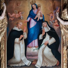 Zdjęcie nr 1: Opis:
Obraz w kształcie stojącego prostokąta, z przedstawieniem Matki Boskiej z Dzieciątkiem oraz św. Dominika i św. Katarzyny ze Sieny. Pośrodku kompozycji, nieco w głębi, na podwyższeniu ukazana w całej postaci Matka Boska, frontalnie, z głową przechyloną w prawą stronę. Ręce ugięte w łokciach, lewą obejmuje siedzącego na jej przedramieniu Jezusa, prawą, wyciągniętą do przodu podaje różaniec św. Dominikowi. Ubrana w bladoróżową, długą suknię z wąskimi rękawami oraz niebieski płaszcz. Na głowie zamknięta korona. Jezus siedzi na ręce Matki z rozsuniętymi nóżkami, okryty jedynie pieluszką i w koronie na głowie. Lewą rączką podaje różaniec św. Katarzynie. Św. Dominik klęczy po lewej stronie obrazu, ukazany w trzech czwartych, zwrócony w lewo. Ręce ugięte w łokciach, lewą sięga po różaniec. Ubrany w habit dominikański (białą tunikę ze szkaplerzem oraz czarną kapę z kapturem). Św. Katarzyna, ukazana w dynamicznej pozie po prawej stronie kompozycji, przyklęka, wyciągając prawą rękę po różaniec. Ubrana w habit benedyktyński z czarnym welonem. W tle kompozycji rozjaśnione światłem niebo z jasnymi obłokami, wśród których uskrzydlone putta niosące wieńce z białych kwiatów oraz uskrzydlone główki aniołków. 
