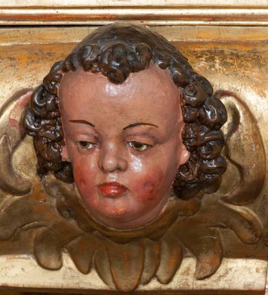 Zdjęcie nr 47: Ołtarz architektoniczny, z wydzieloną predellą, trójosiowy, dwukondygnacyjny ze zwieńczeniem. Predella węższa od nastawy, rozszerzająca się ku górze. Dolna kondygnacja artykułowana kolumnami o trzonach przedzielonych opaską w jednej trzeciej wysokości, zdobionych główkami aniołków, girlandami i dekoracją kandelabrową; kapitele kompozytowe; w osiach zewnętrznych kolumny nadwieszone na konsolach, w osiach wewnętrznych ustawione na postumentach. Kolumny wspierają belkowanie i gzyms występujące nad nimi. W polu środkowym prostokątna nisza zamknięta półkoliście, w niej obraz: Chrzest Chrystusa; w polach bocznych mniejsze nisze prostokątne zamknięte półkoliście, muszlowe, w nich rzeźby: Św. Piotr i Św. Paweł. Górna kondygnacja ujęta kolumnami o kręconych trzonach z dekoracją roślinną i kompozytowych kapitelach, wspierającymi belkowanie i profilowany gzyms. W polu środkowym nisza zamknięta półkoliście w niej obraz: Matka Boska z Dzieciątkiem. Po bokach obrazu rzeźby: Św. Anna (?) i Św. Marcin (?). Dolna i górna kondygnacje flankowane rzeźbionymi, ażurowymi uszakami z motywem herm aniołów. W osiach kolumn dolnej kondygnacji rzeźby: Św. Wojciech i Św. Stanisław. Zwieńczenie w kształcie półkolistego przyczółka wspartego na konsoli wchodzącej w pole górnej kondygnacji. W polu zwieńczenia płaskorzeźbione, półplastyczne przedstawienie Boga Ojca w popiersiu, flankowane wolutami z półpostaciami dwóch uskrzydlonych aniołów. Po bokach w zwieńczeniu, w osiach kolumn górnej kondygnacji, rzeźby uskrzydlonych aniołów.   W szczycie ołtarza na konsoli rzeźba: Św. Michał Archanioł. W przyłuczach nisz na obrazy, ponad niszami na rzeźby, w predelli, na konsolach i postumentach kolumn dolnej kondygnacji oraz na konsoli poniżej zwieńczenia uskrzydlone główki aniołków. Ponadto poniżej nisz, w tle kolumn oraz na belkowaniu płyciny ornamentalne z motywów roślinnych i motywy rautów. Struktura ołtarza, rzeźby i ornamenty złocone, karnacje i włosy polichromowane.  
