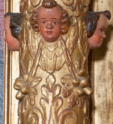 Zdjęcie nr 30: Ołtarz architektoniczny, z wydzieloną predellą, trójosiowy, dwukondygnacyjny ze zwieńczeniem. Predella węższa od nastawy, rozszerzająca się ku górze. Dolna kondygnacja artykułowana kolumnami o trzonach przedzielonych opaską w jednej trzeciej wysokości, zdobionych główkami aniołków, girlandami i dekoracją kandelabrową; kapitele kompozytowe; w osiach zewnętrznych kolumny nadwieszone na konsolach, w osiach wewnętrznych ustawione na postumentach. Kolumny wspierają belkowanie i gzyms występujące nad nimi. W polu środkowym prostokątna nisza zamknięta półkoliście, w niej obraz: Chrzest Chrystusa; w polach bocznych mniejsze nisze prostokątne zamknięte półkoliście, muszlowe, w nich rzeźby: Św. Piotr i Św. Paweł. Górna kondygnacja ujęta kolumnami o kręconych trzonach z dekoracją roślinną i kompozytowych kapitelach, wspierającymi belkowanie i profilowany gzyms. W polu środkowym nisza zamknięta półkoliście w niej obraz: Matka Boska z Dzieciątkiem. Po bokach obrazu rzeźby: Św. Anna (?) i Św. Marcin (?). Dolna i górna kondygnacje flankowane rzeźbionymi, ażurowymi uszakami z motywem herm aniołów. W osiach kolumn dolnej kondygnacji rzeźby: Św. Wojciech i Św. Stanisław. Zwieńczenie w kształcie półkolistego przyczółka wspartego na konsoli wchodzącej w pole górnej kondygnacji. W polu zwieńczenia płaskorzeźbione, półplastyczne przedstawienie Boga Ojca w popiersiu, flankowane wolutami z półpostaciami dwóch uskrzydlonych aniołów. Po bokach w zwieńczeniu, w osiach kolumn górnej kondygnacji, rzeźby uskrzydlonych aniołów.   W szczycie ołtarza na konsoli rzeźba: Św. Michał Archanioł. W przyłuczach nisz na obrazy, ponad niszami na rzeźby, w predelli, na konsolach i postumentach kolumn dolnej kondygnacji oraz na konsoli poniżej zwieńczenia uskrzydlone główki aniołków. Ponadto poniżej nisz, w tle kolumn oraz na belkowaniu płyciny ornamentalne z motywów roślinnych i motywy rautów. Struktura ołtarza, rzeźby i ornamenty złocone, karnacje i włosy polichromowane.  
