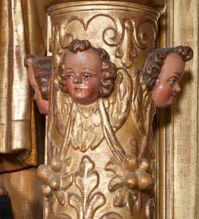 Zdjęcie nr 29: Ołtarz architektoniczny, z wydzieloną predellą, trójosiowy, dwukondygnacyjny ze zwieńczeniem. Predella węższa od nastawy, rozszerzająca się ku górze. Dolna kondygnacja artykułowana kolumnami o trzonach przedzielonych opaską w jednej trzeciej wysokości, zdobionych główkami aniołków, girlandami i dekoracją kandelabrową; kapitele kompozytowe; w osiach zewnętrznych kolumny nadwieszone na konsolach, w osiach wewnętrznych ustawione na postumentach. Kolumny wspierają belkowanie i gzyms występujące nad nimi. W polu środkowym prostokątna nisza zamknięta półkoliście, w niej obraz: Chrzest Chrystusa; w polach bocznych mniejsze nisze prostokątne zamknięte półkoliście, muszlowe, w nich rzeźby: Św. Piotr i Św. Paweł. Górna kondygnacja ujęta kolumnami o kręconych trzonach z dekoracją roślinną i kompozytowych kapitelach, wspierającymi belkowanie i profilowany gzyms. W polu środkowym nisza zamknięta półkoliście w niej obraz: Matka Boska z Dzieciątkiem. Po bokach obrazu rzeźby: Św. Anna (?) i Św. Marcin (?). Dolna i górna kondygnacje flankowane rzeźbionymi, ażurowymi uszakami z motywem herm aniołów. W osiach kolumn dolnej kondygnacji rzeźby: Św. Wojciech i Św. Stanisław. Zwieńczenie w kształcie półkolistego przyczółka wspartego na konsoli wchodzącej w pole górnej kondygnacji. W polu zwieńczenia płaskorzeźbione, półplastyczne przedstawienie Boga Ojca w popiersiu, flankowane wolutami z półpostaciami dwóch uskrzydlonych aniołów. Po bokach w zwieńczeniu, w osiach kolumn górnej kondygnacji, rzeźby uskrzydlonych aniołów.   W szczycie ołtarza na konsoli rzeźba: Św. Michał Archanioł. W przyłuczach nisz na obrazy, ponad niszami na rzeźby, w predelli, na konsolach i postumentach kolumn dolnej kondygnacji oraz na konsoli poniżej zwieńczenia uskrzydlone główki aniołków. Ponadto poniżej nisz, w tle kolumn oraz na belkowaniu płyciny ornamentalne z motywów roślinnych i motywy rautów. Struktura ołtarza, rzeźby i ornamenty złocone, karnacje i włosy polichromowane.  
