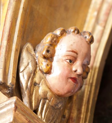 Zdjęcie nr 40: Ołtarz architektoniczny, z wydzieloną predellą, trójosiowy, dwukondygnacyjny ze zwieńczeniem. Predella węższa od nastawy, rozszerzająca się ku górze. Dolna kondygnacja artykułowana kolumnami o trzonach przedzielonych opaską w jednej trzeciej wysokości, zdobionych główkami aniołków, girlandami i dekoracją kandelabrową; kapitele kompozytowe; w osiach zewnętrznych kolumny nadwieszone na konsolach, w osiach wewnętrznych ustawione na postumentach. Kolumny wspierają belkowanie i gzyms występujące nad nimi. W polu środkowym prostokątna nisza zamknięta półkoliście, w niej obraz: Chrzest Chrystusa; w polach bocznych mniejsze nisze prostokątne zamknięte półkoliście, muszlowe, w nich rzeźby: Św. Piotr i Św. Paweł. Górna kondygnacja ujęta kolumnami o kręconych trzonach z dekoracją roślinną i kompozytowych kapitelach, wspierającymi belkowanie i profilowany gzyms. W polu środkowym nisza zamknięta półkoliście w niej obraz: Matka Boska z Dzieciątkiem. Po bokach obrazu rzeźby: Św. Anna (?) i Św. Marcin (?). Dolna i górna kondygnacje flankowane rzeźbionymi, ażurowymi uszakami z motywem herm aniołów. W osiach kolumn dolnej kondygnacji rzeźby: Św. Wojciech i Św. Stanisław. Zwieńczenie w kształcie półkolistego przyczółka wspartego na konsoli wchodzącej w pole górnej kondygnacji. W polu zwieńczenia płaskorzeźbione, półplastyczne przedstawienie Boga Ojca w popiersiu, flankowane wolutami z półpostaciami dwóch uskrzydlonych aniołów. Po bokach w zwieńczeniu, w osiach kolumn górnej kondygnacji, rzeźby uskrzydlonych aniołów.   W szczycie ołtarza na konsoli rzeźba: Św. Michał Archanioł. W przyłuczach nisz na obrazy, ponad niszami na rzeźby, w predelli, na konsolach i postumentach kolumn dolnej kondygnacji oraz na konsoli poniżej zwieńczenia uskrzydlone główki aniołków. Ponadto poniżej nisz, w tle kolumn oraz na belkowaniu płyciny ornamentalne z motywów roślinnych i motywy rautów. Struktura ołtarza, rzeźby i ornamenty złocone, karnacje i włosy polichromowane.  
