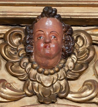 Zdjęcie nr 48: Ołtarz architektoniczny, z wydzieloną predellą, trójosiowy, dwukondygnacyjny ze zwieńczeniem. Predella węższa od nastawy, rozszerzająca się ku górze. Dolna kondygnacja artykułowana kolumnami o trzonach przedzielonych opaską w jednej trzeciej wysokości, zdobionych główkami aniołków, girlandami i dekoracją kandelabrową; kapitele kompozytowe; w osiach zewnętrznych kolumny nadwieszone na konsolach, w osiach wewnętrznych ustawione na postumentach. Kolumny wspierają belkowanie i gzyms występujące nad nimi. W polu środkowym prostokątna nisza zamknięta półkoliście, w niej obraz: Chrzest Chrystusa; w polach bocznych mniejsze nisze prostokątne zamknięte półkoliście, muszlowe, w nich rzeźby: Św. Piotr i Św. Paweł. Górna kondygnacja ujęta kolumnami o kręconych trzonach z dekoracją roślinną i kompozytowych kapitelach, wspierającymi belkowanie i profilowany gzyms. W polu środkowym nisza zamknięta półkoliście w niej obraz: Matka Boska z Dzieciątkiem. Po bokach obrazu rzeźby: Św. Anna (?) i Św. Marcin (?). Dolna i górna kondygnacje flankowane rzeźbionymi, ażurowymi uszakami z motywem herm aniołów. W osiach kolumn dolnej kondygnacji rzeźby: Św. Wojciech i Św. Stanisław. Zwieńczenie w kształcie półkolistego przyczółka wspartego na konsoli wchodzącej w pole górnej kondygnacji. W polu zwieńczenia płaskorzeźbione, półplastyczne przedstawienie Boga Ojca w popiersiu, flankowane wolutami z półpostaciami dwóch uskrzydlonych aniołów. Po bokach w zwieńczeniu, w osiach kolumn górnej kondygnacji, rzeźby uskrzydlonych aniołów.   W szczycie ołtarza na konsoli rzeźba: Św. Michał Archanioł. W przyłuczach nisz na obrazy, ponad niszami na rzeźby, w predelli, na konsolach i postumentach kolumn dolnej kondygnacji oraz na konsoli poniżej zwieńczenia uskrzydlone główki aniołków. Ponadto poniżej nisz, w tle kolumn oraz na belkowaniu płyciny ornamentalne z motywów roślinnych i motywy rautów. Struktura ołtarza, rzeźby i ornamenty złocone, karnacje i włosy polichromowane.  
