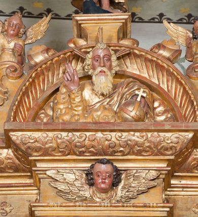 Zdjęcie nr 53: Ołtarz architektoniczny, z wydzieloną predellą, trójosiowy, dwukondygnacyjny ze zwieńczeniem. Predella węższa od nastawy, rozszerzająca się ku górze. Dolna kondygnacja artykułowana kolumnami o trzonach przedzielonych opaską w jednej trzeciej wysokości, zdobionych główkami aniołków, girlandami i dekoracją kandelabrową; kapitele kompozytowe; w osiach zewnętrznych kolumny nadwieszone na konsolach, w osiach wewnętrznych ustawione na postumentach. Kolumny wspierają belkowanie i gzyms występujące nad nimi. W polu środkowym prostokątna nisza zamknięta półkoliście, w niej obraz: Chrzest Chrystusa; w polach bocznych mniejsze nisze prostokątne zamknięte półkoliście, muszlowe, w nich rzeźby: Św. Piotr i Św. Paweł. Górna kondygnacja ujęta kolumnami o kręconych trzonach z dekoracją roślinną i kompozytowych kapitelach, wspierającymi belkowanie i profilowany gzyms. W polu środkowym nisza zamknięta półkoliście w niej obraz: Matka Boska z Dzieciątkiem. Po bokach obrazu rzeźby: Św. Anna (?) i Św. Marcin (?). Dolna i górna kondygnacje flankowane rzeźbionymi, ażurowymi uszakami z motywem herm aniołów. W osiach kolumn dolnej kondygnacji rzeźby: Św. Wojciech i Św. Stanisław. Zwieńczenie w kształcie półkolistego przyczółka wspartego na konsoli wchodzącej w pole górnej kondygnacji. W polu zwieńczenia płaskorzeźbione, półplastyczne przedstawienie Boga Ojca w popiersiu, flankowane wolutami z półpostaciami dwóch uskrzydlonych aniołów. Po bokach w zwieńczeniu, w osiach kolumn górnej kondygnacji, rzeźby uskrzydlonych aniołów.   W szczycie ołtarza na konsoli rzeźba: Św. Michał Archanioł. W przyłuczach nisz na obrazy, ponad niszami na rzeźby, w predelli, na konsolach i postumentach kolumn dolnej kondygnacji oraz na konsoli poniżej zwieńczenia uskrzydlone główki aniołków. Ponadto poniżej nisz, w tle kolumn oraz na belkowaniu płyciny ornamentalne z motywów roślinnych i motywy rautów. Struktura ołtarza, rzeźby i ornamenty złocone, karnacje i włosy polichromowane.  
