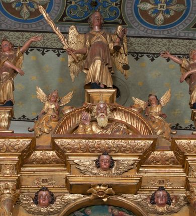 Zdjęcie nr 46: Ołtarz architektoniczny, z wydzieloną predellą, trójosiowy, dwukondygnacyjny ze zwieńczeniem. Predella węższa od nastawy, rozszerzająca się ku górze. Dolna kondygnacja artykułowana kolumnami o trzonach przedzielonych opaską w jednej trzeciej wysokości, zdobionych główkami aniołków, girlandami i dekoracją kandelabrową; kapitele kompozytowe; w osiach zewnętrznych kolumny nadwieszone na konsolach, w osiach wewnętrznych ustawione na postumentach. Kolumny wspierają belkowanie i gzyms występujące nad nimi. W polu środkowym prostokątna nisza zamknięta półkoliście, w niej obraz: Chrzest Chrystusa; w polach bocznych mniejsze nisze prostokątne zamknięte półkoliście, muszlowe, w nich rzeźby: Św. Piotr i Św. Paweł. Górna kondygnacja ujęta kolumnami o kręconych trzonach z dekoracją roślinną i kompozytowych kapitelach, wspierającymi belkowanie i profilowany gzyms. W polu środkowym nisza zamknięta półkoliście w niej obraz: Matka Boska z Dzieciątkiem. Po bokach obrazu rzeźby: Św. Anna (?) i Św. Marcin (?). Dolna i górna kondygnacje flankowane rzeźbionymi, ażurowymi uszakami z motywem herm aniołów. W osiach kolumn dolnej kondygnacji rzeźby: Św. Wojciech i Św. Stanisław. Zwieńczenie w kształcie półkolistego przyczółka wspartego na konsoli wchodzącej w pole górnej kondygnacji. W polu zwieńczenia płaskorzeźbione, półplastyczne przedstawienie Boga Ojca w popiersiu, flankowane wolutami z półpostaciami dwóch uskrzydlonych aniołów. Po bokach w zwieńczeniu, w osiach kolumn górnej kondygnacji, rzeźby uskrzydlonych aniołów.   W szczycie ołtarza na konsoli rzeźba: Św. Michał Archanioł. W przyłuczach nisz na obrazy, ponad niszami na rzeźby, w predelli, na konsolach i postumentach kolumn dolnej kondygnacji oraz na konsoli poniżej zwieńczenia uskrzydlone główki aniołków. Ponadto poniżej nisz, w tle kolumn oraz na belkowaniu płyciny ornamentalne z motywów roślinnych i motywy rautów. Struktura ołtarza, rzeźby i ornamenty złocone, karnacje i włosy polichromowane.  
