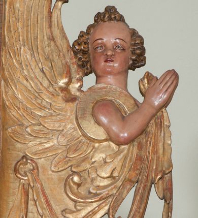 Zdjęcie nr 37: Ołtarz architektoniczny, z wydzieloną predellą, trójosiowy, dwukondygnacyjny ze zwieńczeniem. Predella węższa od nastawy, rozszerzająca się ku górze. Dolna kondygnacja artykułowana kolumnami o trzonach przedzielonych opaską w jednej trzeciej wysokości, zdobionych główkami aniołków, girlandami i dekoracją kandelabrową; kapitele kompozytowe; w osiach zewnętrznych kolumny nadwieszone na konsolach, w osiach wewnętrznych ustawione na postumentach. Kolumny wspierają belkowanie i gzyms występujące nad nimi. W polu środkowym prostokątna nisza zamknięta półkoliście, w niej obraz: Chrzest Chrystusa; w polach bocznych mniejsze nisze prostokątne zamknięte półkoliście, muszlowe, w nich rzeźby: Św. Piotr i Św. Paweł. Górna kondygnacja ujęta kolumnami o kręconych trzonach z dekoracją roślinną i kompozytowych kapitelach, wspierającymi belkowanie i profilowany gzyms. W polu środkowym nisza zamknięta półkoliście w niej obraz: Matka Boska z Dzieciątkiem. Po bokach obrazu rzeźby: Św. Anna (?) i Św. Marcin (?). Dolna i górna kondygnacje flankowane rzeźbionymi, ażurowymi uszakami z motywem herm aniołów. W osiach kolumn dolnej kondygnacji rzeźby: Św. Wojciech i Św. Stanisław. Zwieńczenie w kształcie półkolistego przyczółka wspartego na konsoli wchodzącej w pole górnej kondygnacji. W polu zwieńczenia płaskorzeźbione, półplastyczne przedstawienie Boga Ojca w popiersiu, flankowane wolutami z półpostaciami dwóch uskrzydlonych aniołów. Po bokach w zwieńczeniu, w osiach kolumn górnej kondygnacji, rzeźby uskrzydlonych aniołów.   W szczycie ołtarza na konsoli rzeźba: Św. Michał Archanioł. W przyłuczach nisz na obrazy, ponad niszami na rzeźby, w predelli, na konsolach i postumentach kolumn dolnej kondygnacji oraz na konsoli poniżej zwieńczenia uskrzydlone główki aniołków. Ponadto poniżej nisz, w tle kolumn oraz na belkowaniu płyciny ornamentalne z motywów roślinnych i motywy rautów. Struktura ołtarza, rzeźby i ornamenty złocone, karnacje i włosy polichromowane.  
